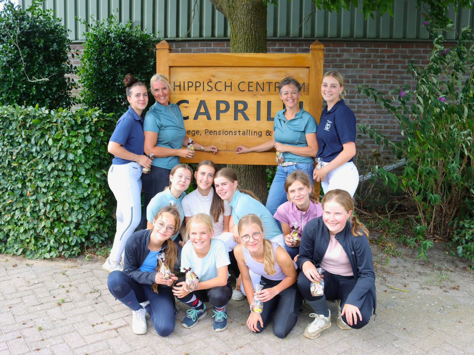 Groepsfoto bij bord PSV Caprilli